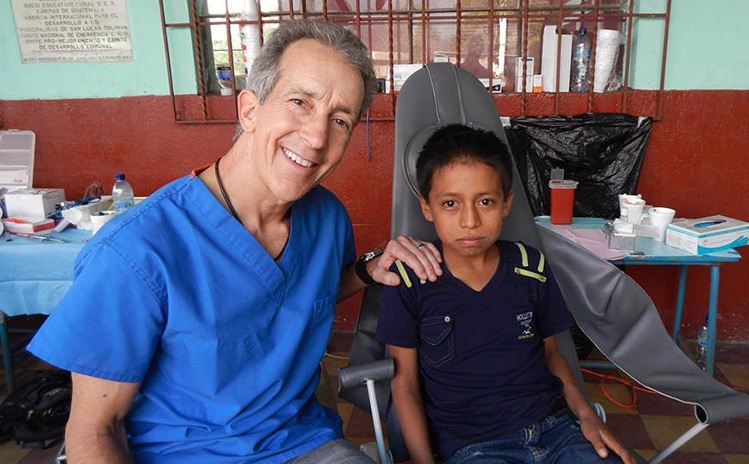 Dentist and child posing on mission trip