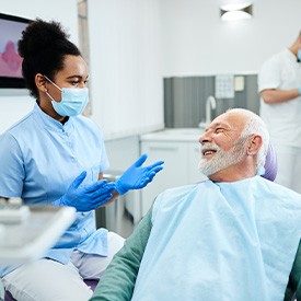 Smiling dentist talking to patient about effects of tooth loss