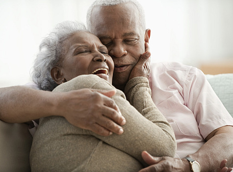 older couple with dentures smiling and embracing